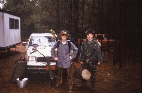 Two young men with bows and packs at the trailhead